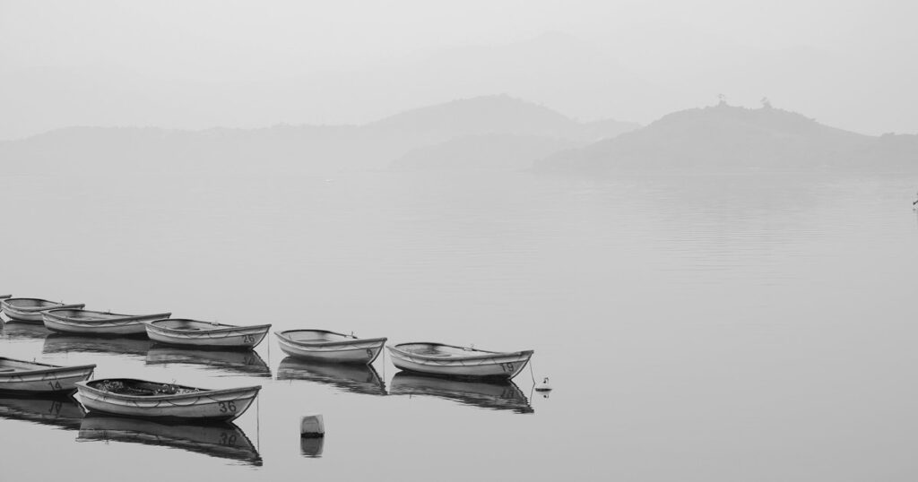 Две лодки на спокойной воде в густом тумане
