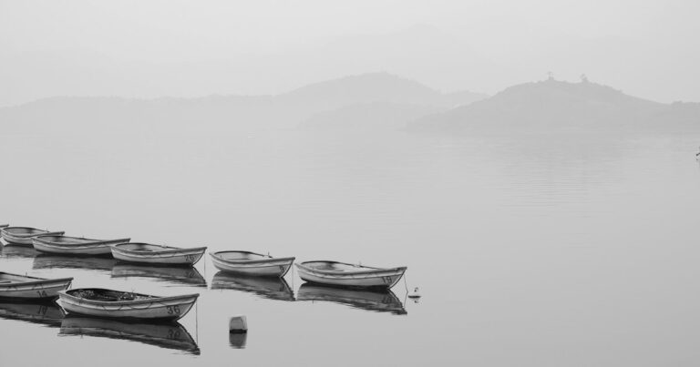 Две лодки на спокойной воде в густом тумане