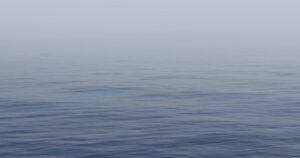 Спокойное серое море и мягкий свет над горизонтом